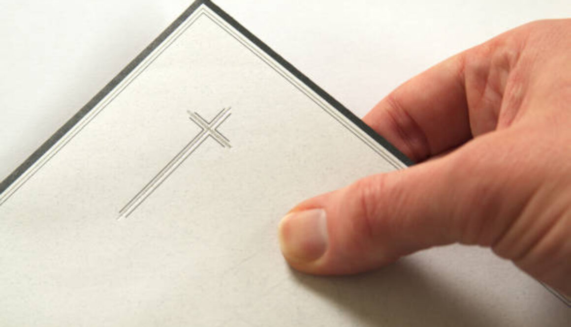 Condolences, hand holding an envelope, invitation for a funeral